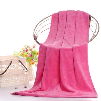 A vibrant pink ultra-absorbent microfiber bath towel draped over a metal hanger.