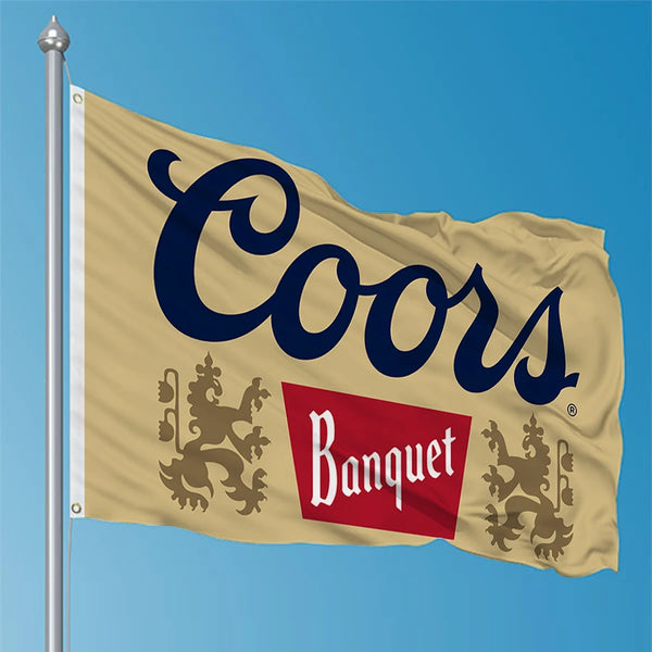 A beige banner featuring the text Coors Banquet on a flagpole against a blue sky.