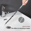 A hand is using a flexible drain cleaning brush with spiral bristles to clean a kitchen sink.