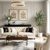 A living room scene featuring a light sofa, wooden coffee table, and an artificial indoor olive tree.