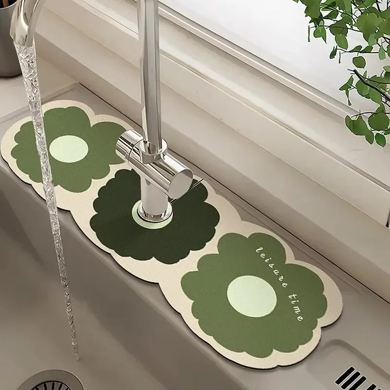 A faucet mat with a green floral design is displayed in a bathroom sink.