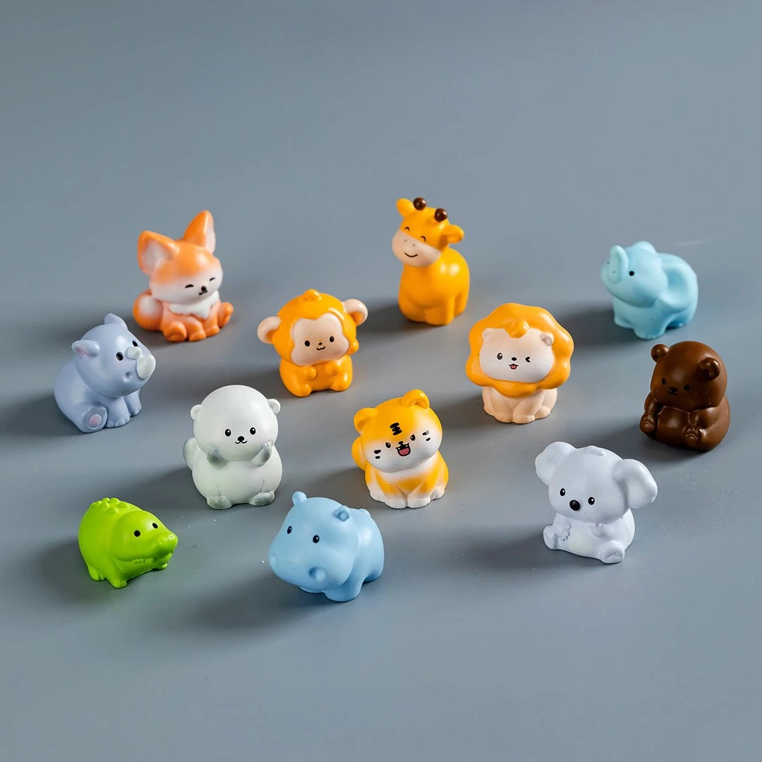 A collection of colorful mini resin cartoon animal figurines arranged on a gray surface.