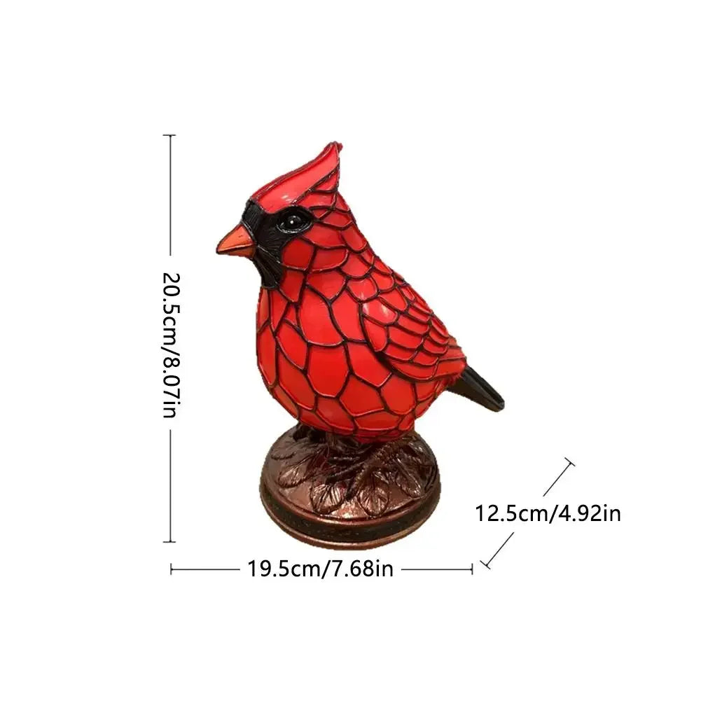 A decorative resin bird sculpture of a red bird perched on a brown base.