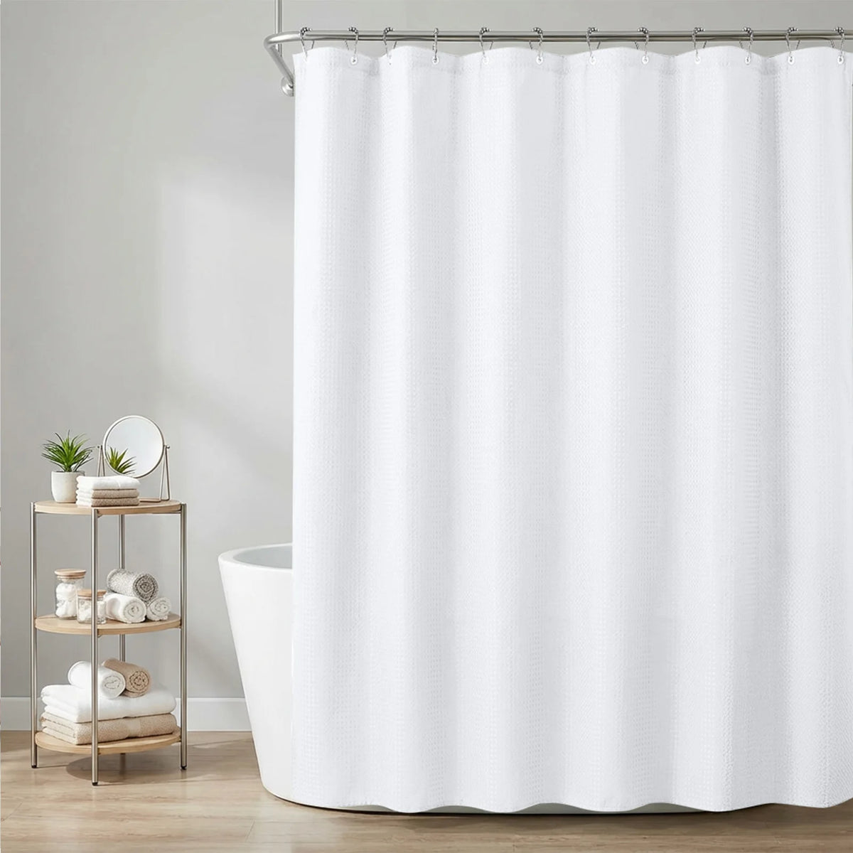 White heavy-duty waffle weave shower curtain hanging from metal hooks