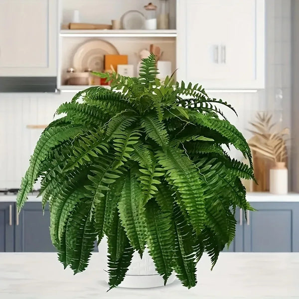 A vibrant green artificial Boston fern plant with lush fronds displayed on a white surface.