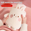 A pink plush rabbit hot water bottle being held by hands, demonstrating its warmth.