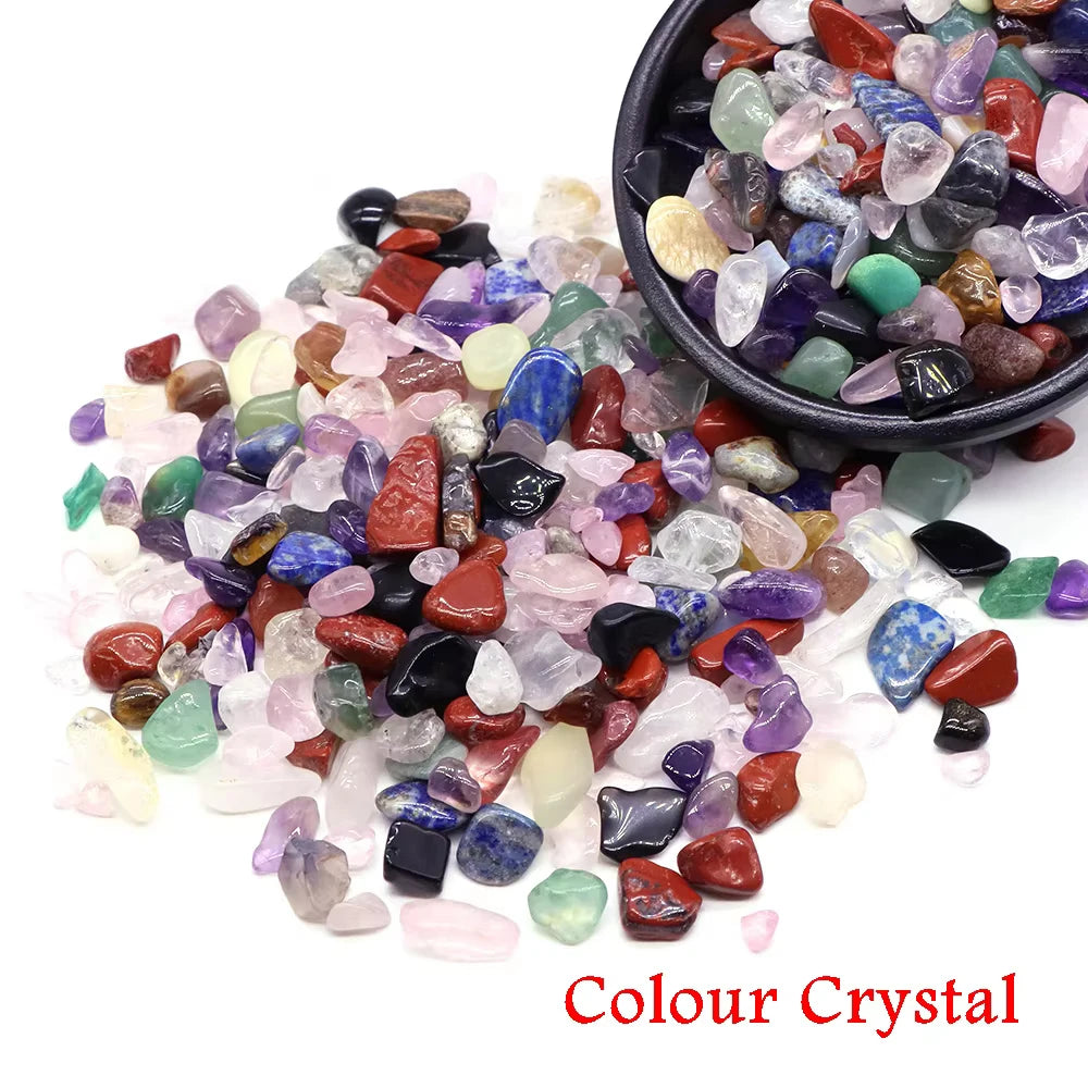 Colección de cristales naturales coloridos en varios tonos y tamaños, exhibidos en un cuenco oscuro.