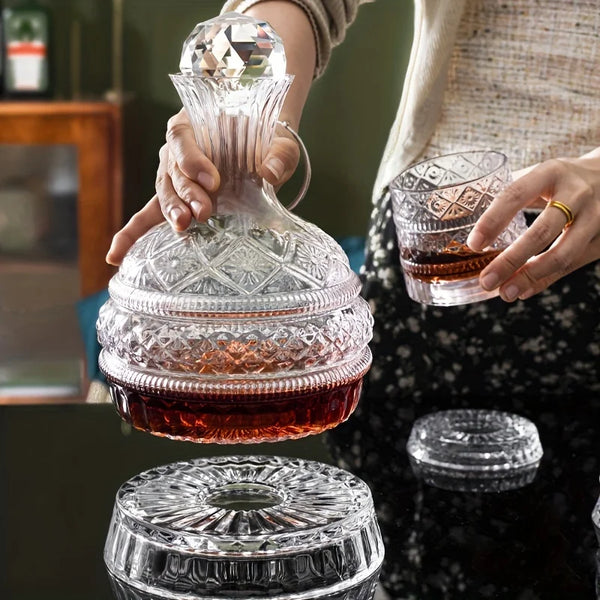 A person pours wine from an elegant glass decanter into a crystal decanter, with a separate glass resting below.