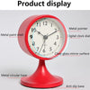 A red analog alarm clock with a metal paint shell and glass mirror surface displayed on a red anti-slip base.