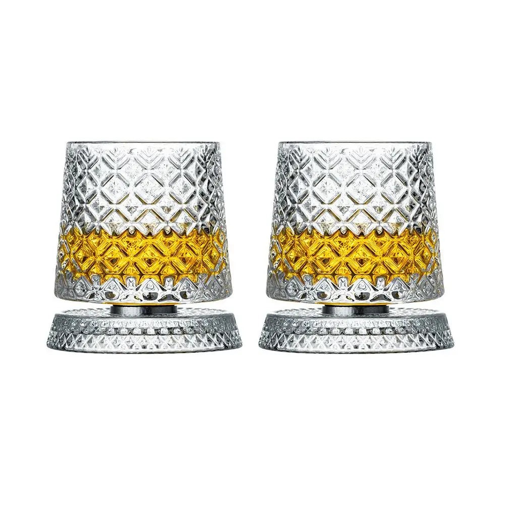 Un par de vasos de whisky plateados facetados con interior dorado y bases a juego.