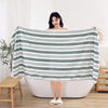 Extra large soft coral fleece bath towel draped over a person in a striped fabric