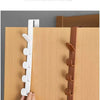 A hand is installing a white door hook rack onto a wooden closet door.