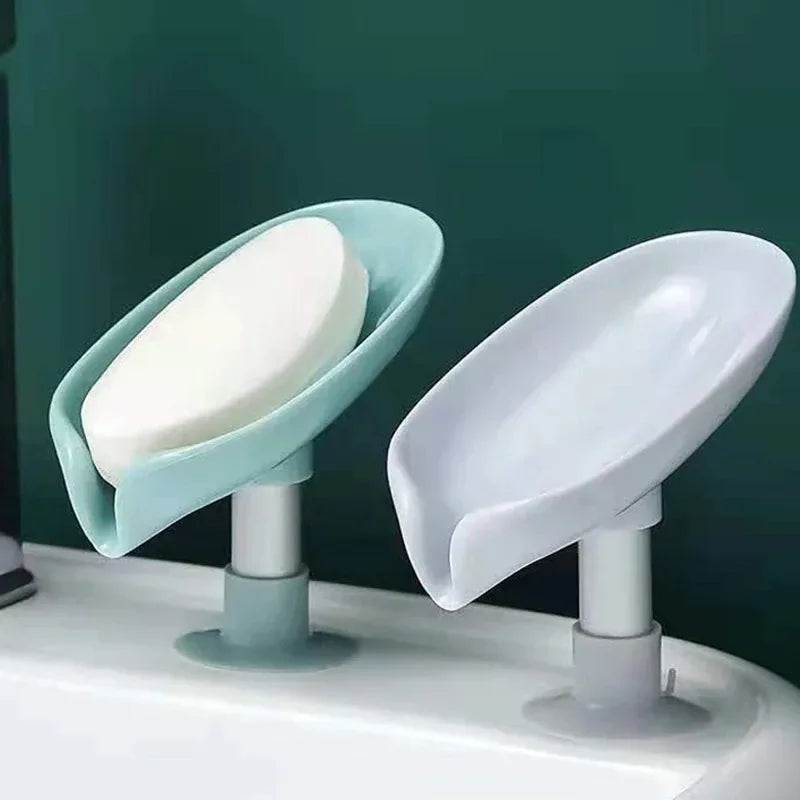 A leaf-shaped suction cup soap holder with a self-draining tray is shown on a white sink.