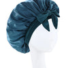 A dark teal silky satin sleep bonnet tied in a bow displayed on a white mannequin head.