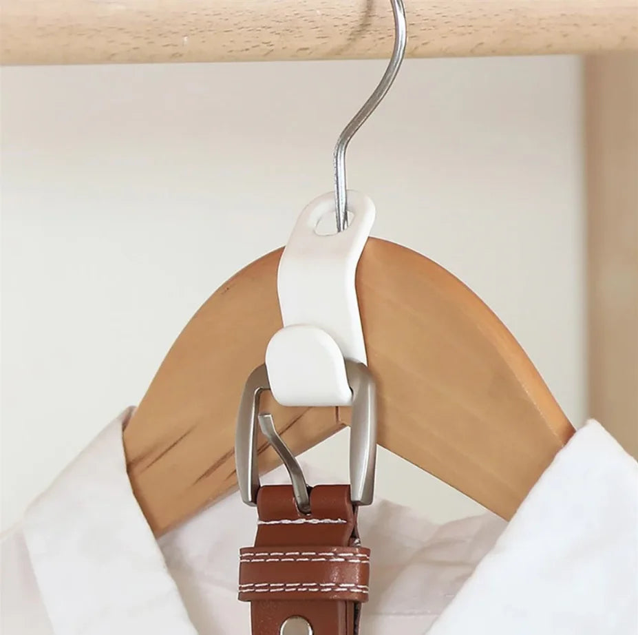 A white plastic clothes hanger hook with a brown leather clip is hanging on a wooden hanger.