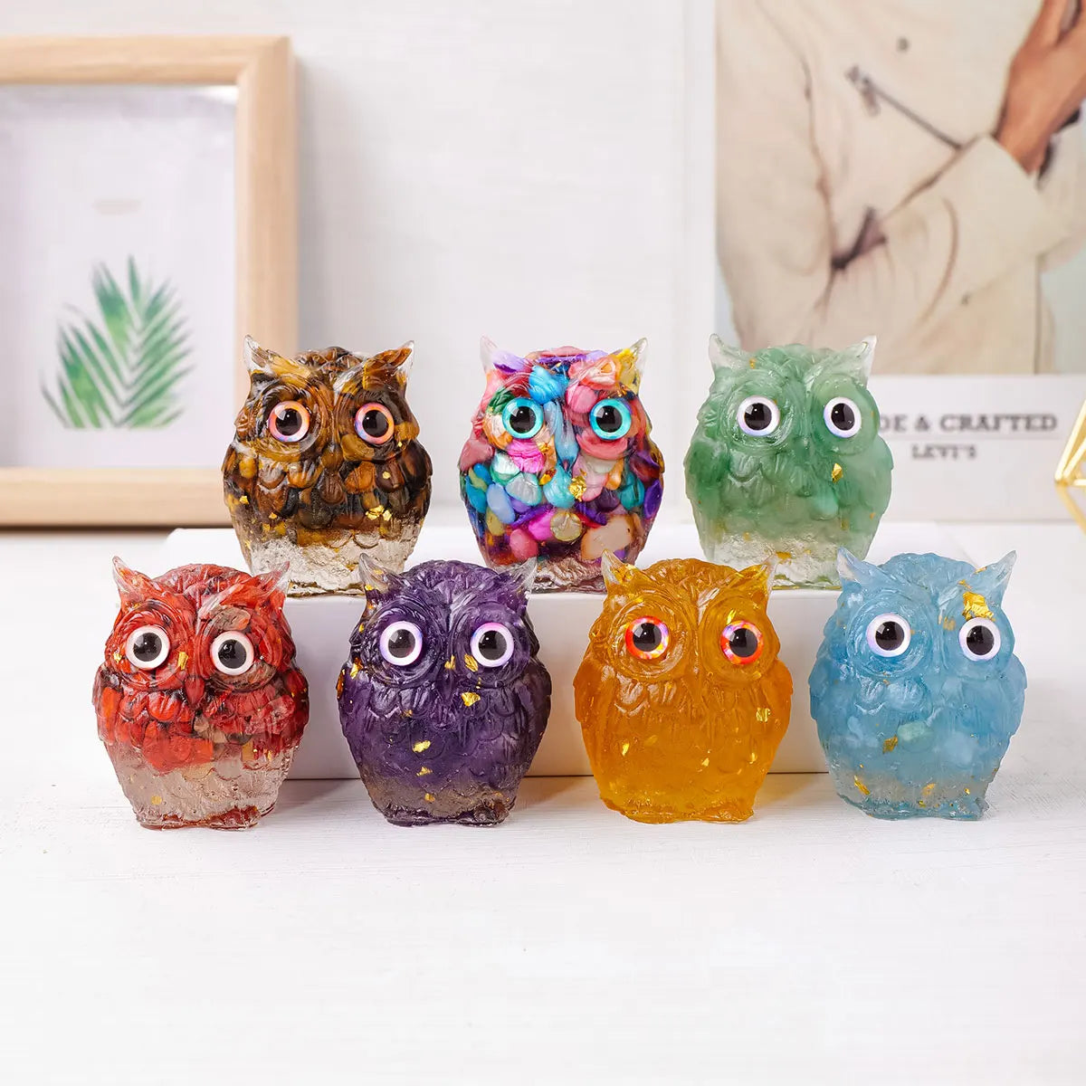 Colección de siete adornos de búho de piedra cristalizada y picada de colores en tonos marrones, morados, verdes y azules.