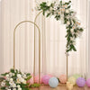 An adjustable gold arch stand decorated with white and green floral arrangements for party decor.