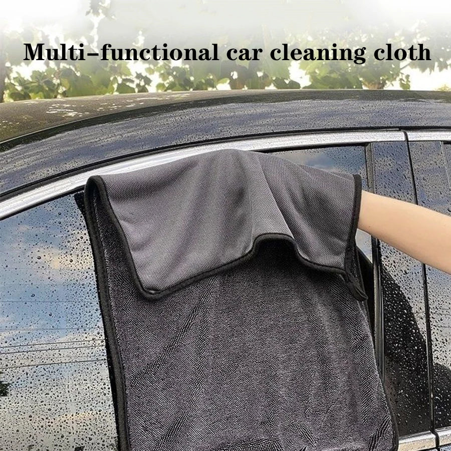 A dark gray multi-functional car cleaning cloth being used to wipe a car window.