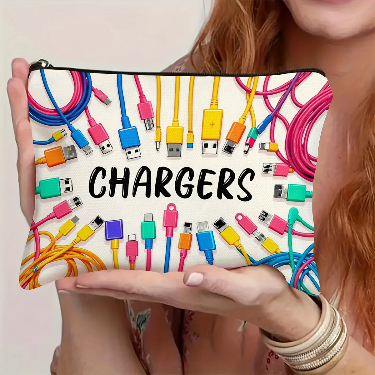 A hand holds a pouch filled with various electronic chargers and cables for organization.