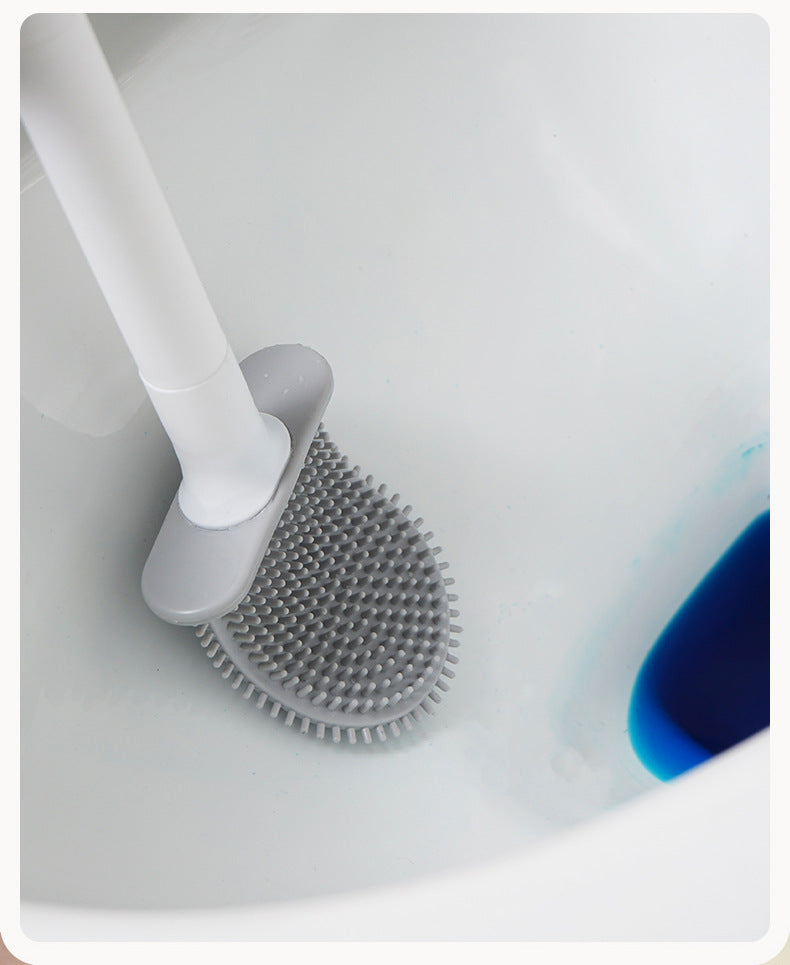 Une brosse à vaisselle en silicone blanche nettoie un évier en céramique blanc.