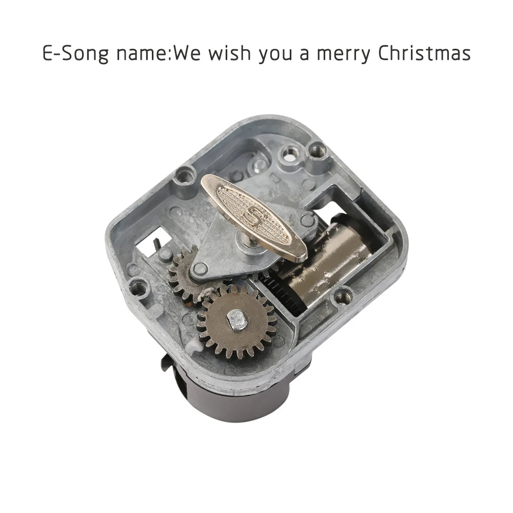 A vintage engraved wooden music box with a metal casing and visible gears.