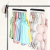 A rack of wooden belt and accessory hangers displaying various colored shirts and tops.