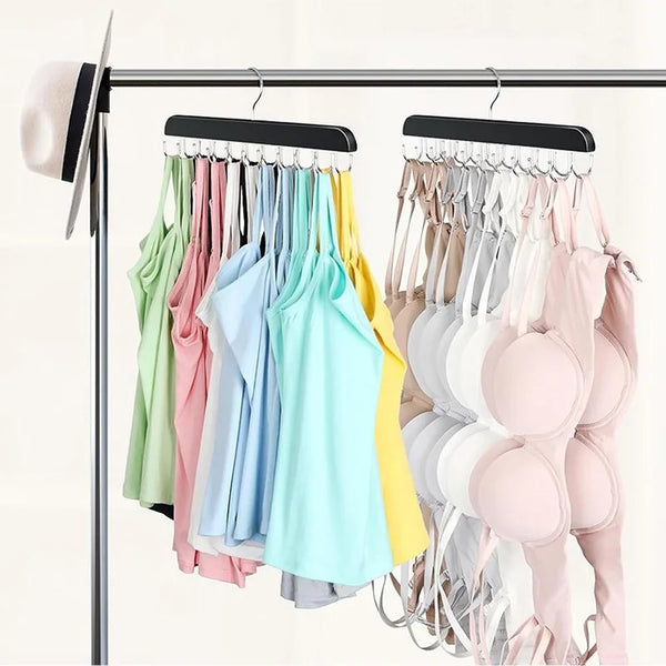 A rack of wooden belt and accessory hangers displaying various colored shirts and tops.