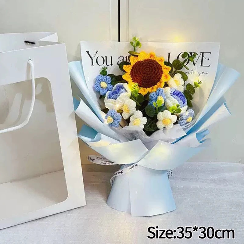 A handmade crochet flower bouquet featuring yellow and blue flowers with a message on the wrapping paper.