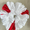 A white and red decorative item made of fluffy yarn resembling a flower or starburst.
