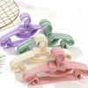 A collection of ten plastic hangers designed in bow shapes and various pastel colors like purple, mint green, and pink.