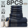A set of eight dark blue bath towels, including square and standard sizes, stacked and displayed on a light gray background.