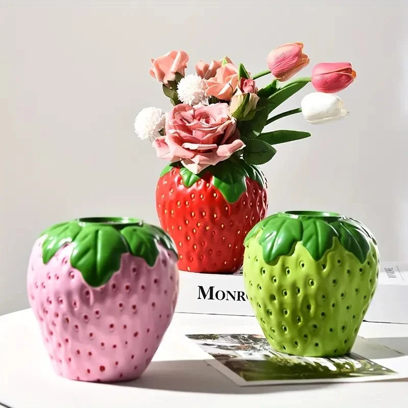 Kreatische, stachelbeerenförmige Harzkunstvase in rosa und grün mit einem Strauß getrockneter Blumen.