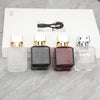 A row of four glass perfume bottles with gold caps and a black silhouette graphic on the box.
