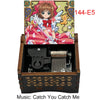 A wooden box containing a musical tone box and an anime-style card featuring a character.