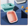 Three colored foldable foot washing buckets in gray, pink, and green are displayed on a blue surface.