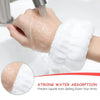 A hand is using a white microfiber wrist sweatband to prevent liquids from spilling down the arms.