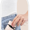 A hand is holding a light pink compact 5-fold travel umbrella in the pocket of blue jeans.