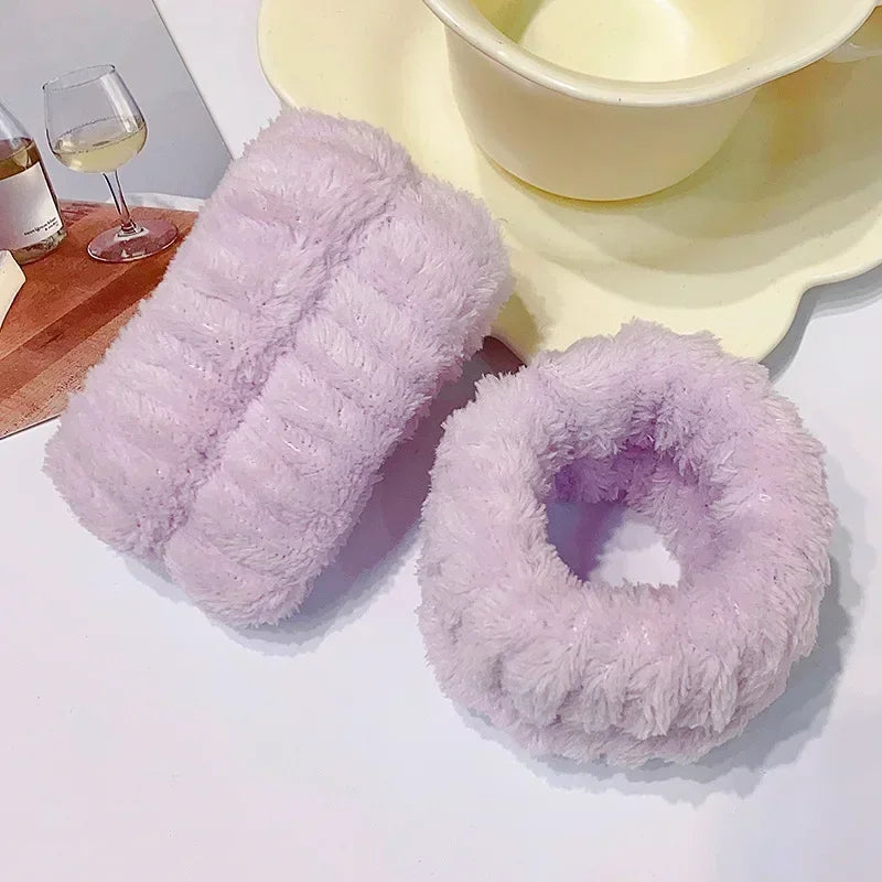 A set of fluffy lavender microfiber wrist sweatbands for face washing and skincare placed next to a bowl.