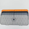 A stack of silicone kitchen sink drainers and splash guard mats in orange, black, and gray.
