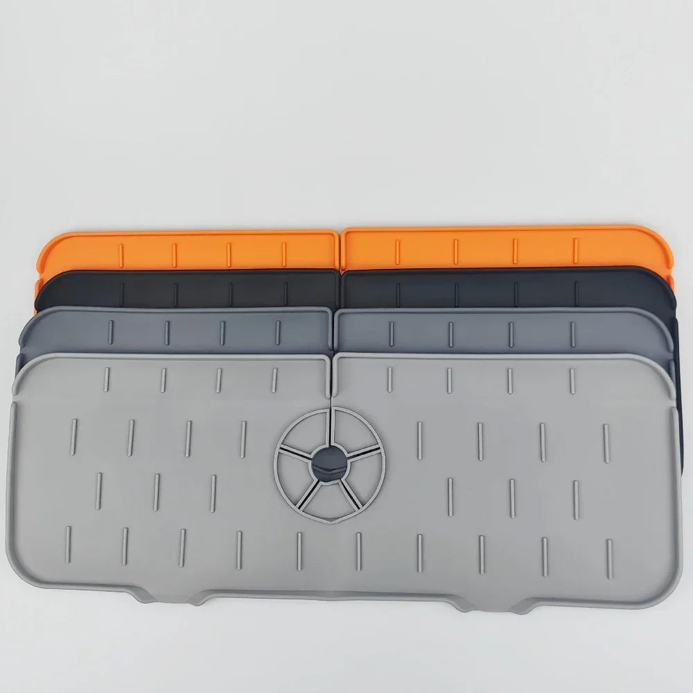 A stack of silicone kitchen sink drainers and splash guard mats in orange, black, and gray.