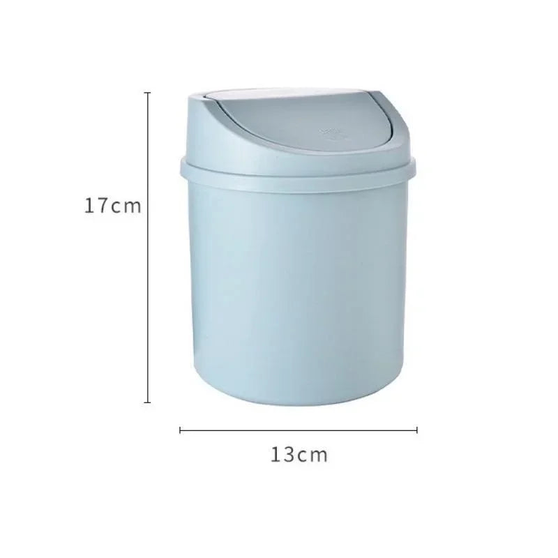 A light blue compact desktop trash can with a flip-top lid, shown from the side and top view.