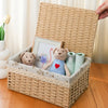 A handwoven rattan storage basket containing a framed picture and stuffed animal toys.