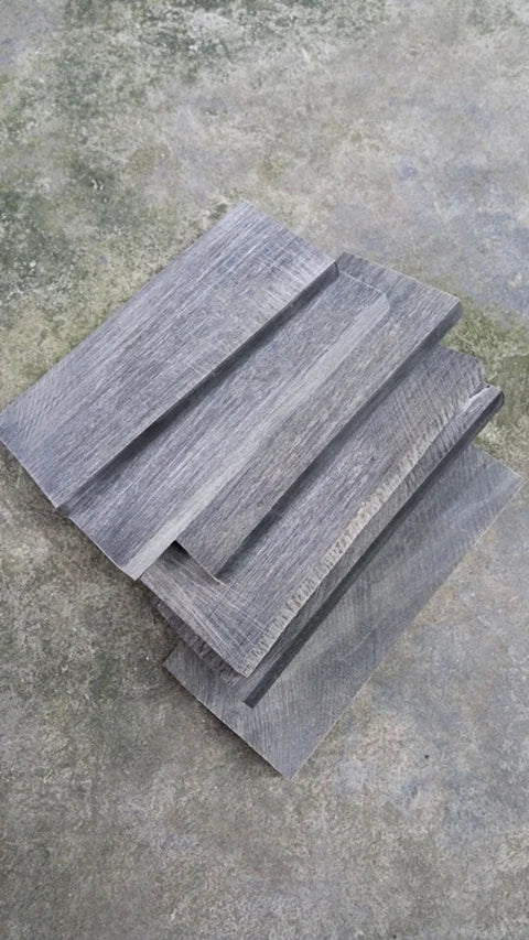 Una pila de dos mangos de cuchillo de cuerno de búfalo naturales con textura de veta de madera gris sobre una superficie de h
