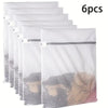 Seis bolsas de lavandería de malla de panal blancas reutilizables apiladas y exhibidas.