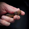 A hand holds a handcrafted wooden pocket cross used for stress relief.