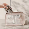 A hand is placing a glass container into a pink silicone leakproof portable soap dish containing skincare products.