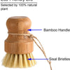 A bamboo dish scrub brush with a wooden handle and sisal bristles.