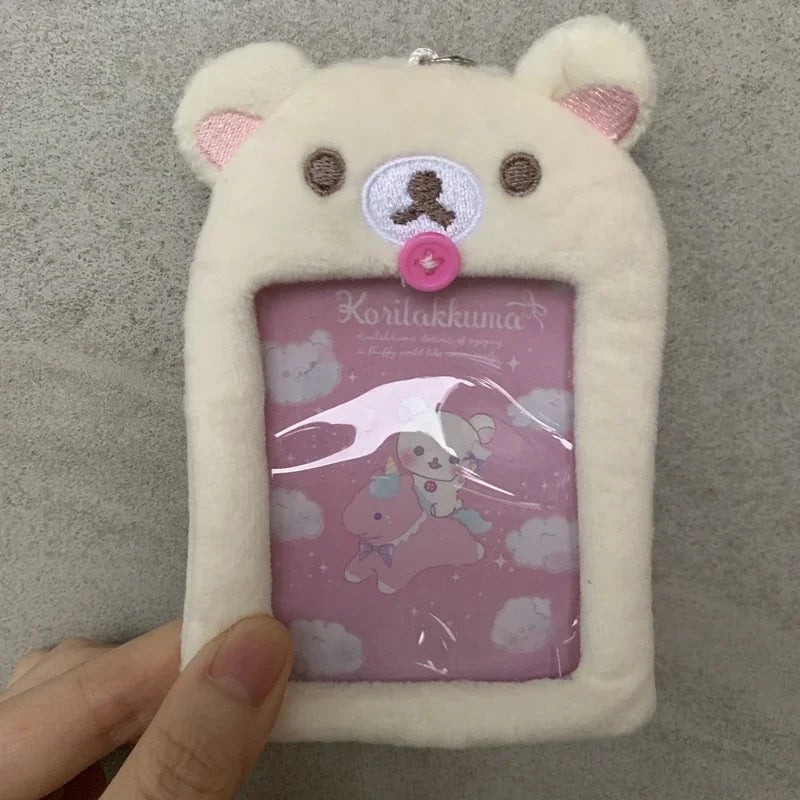 A white Rilakkuma plush card holder keychain with a pink and purple design.