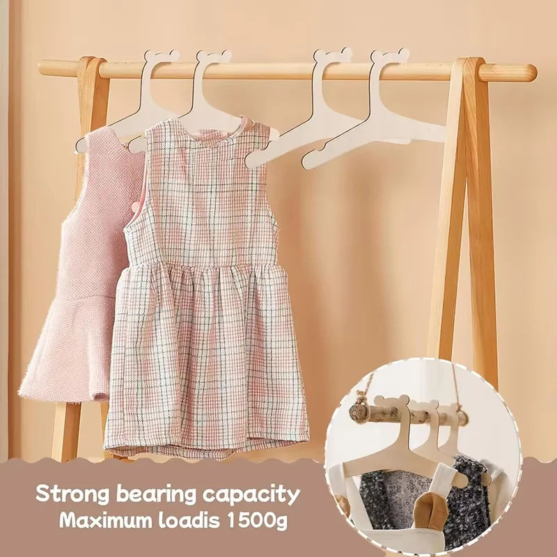 Wooden clothing hangers for kids and apparel showing a pink gingham dress hanging on a wooden rack