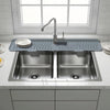 A stainless steel kitchen sink with a silicone splash guard mat and a modern faucet installed in a kitchen countertop.